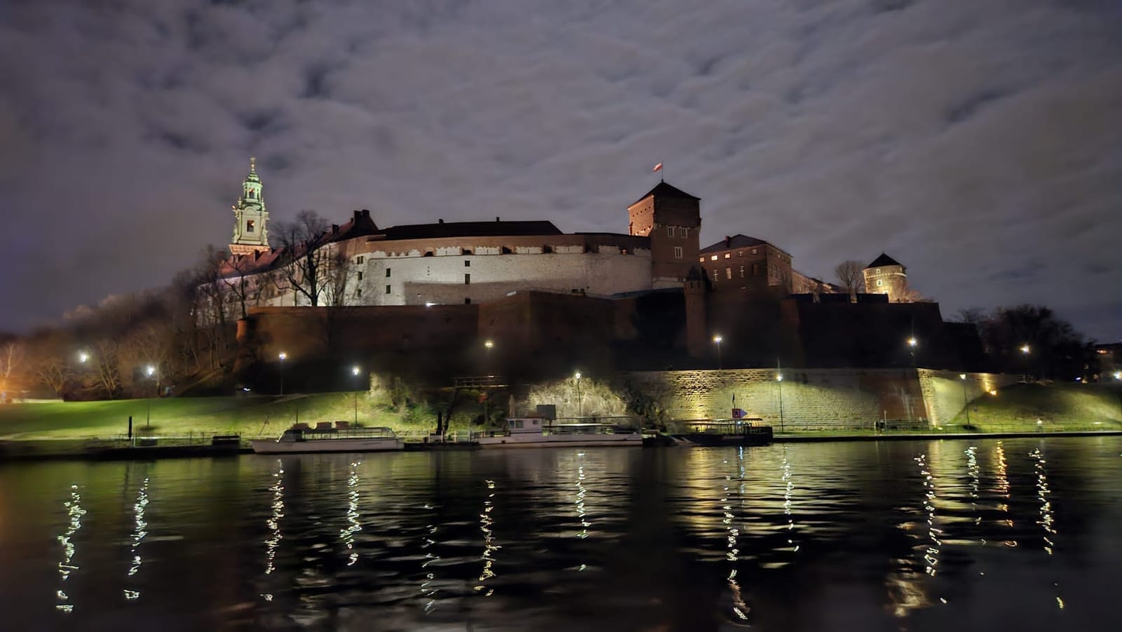 El castillo de Wawel de noche, desde el Vístula